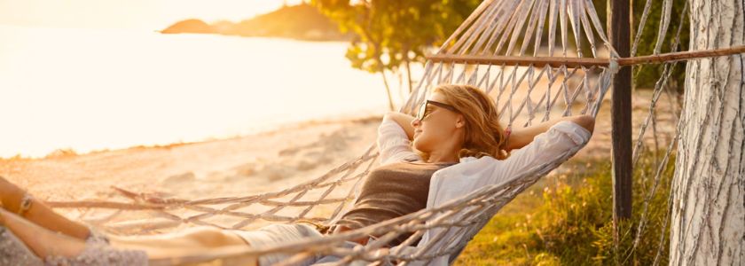Woman relaxing in a hammock outdoors in a calm wellness setting