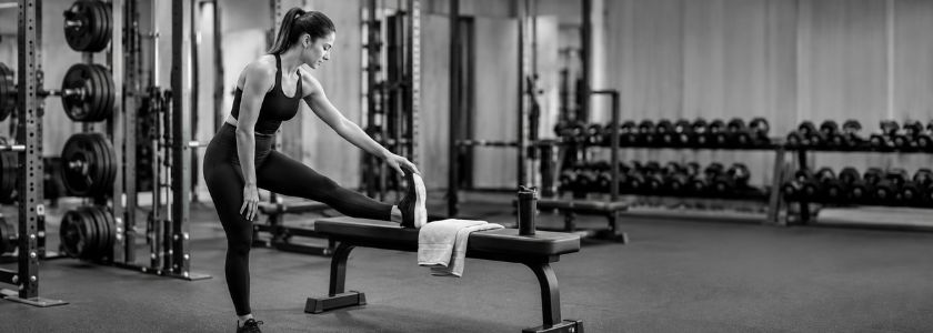 Athlete cooling down with an unbranded shaker in a bright monochrome gym after training